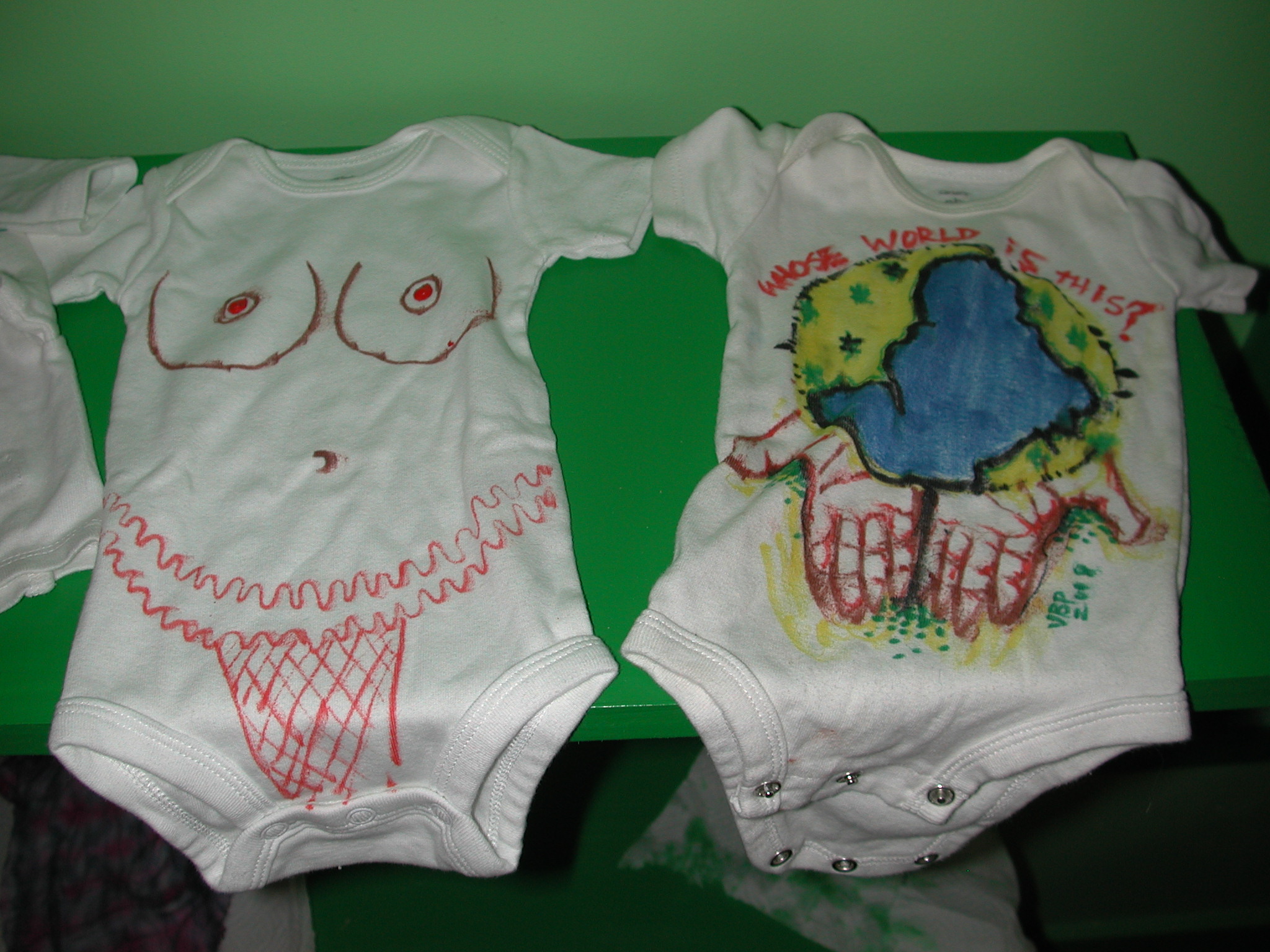 two little ones shirts and one has a baby's head painted on it