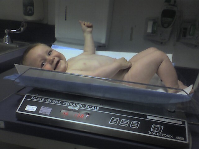 a baby lying on top of a scale in a room