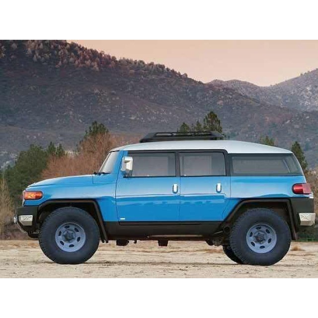 a bright blue 4x4 with a roof rack parked on a dirt road