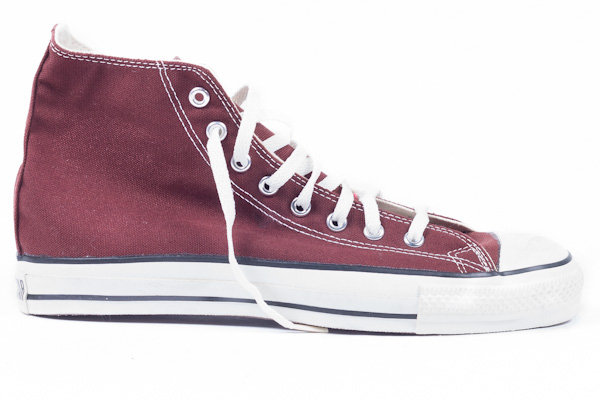 someone is wearing these burgundy high top converse sneakers
