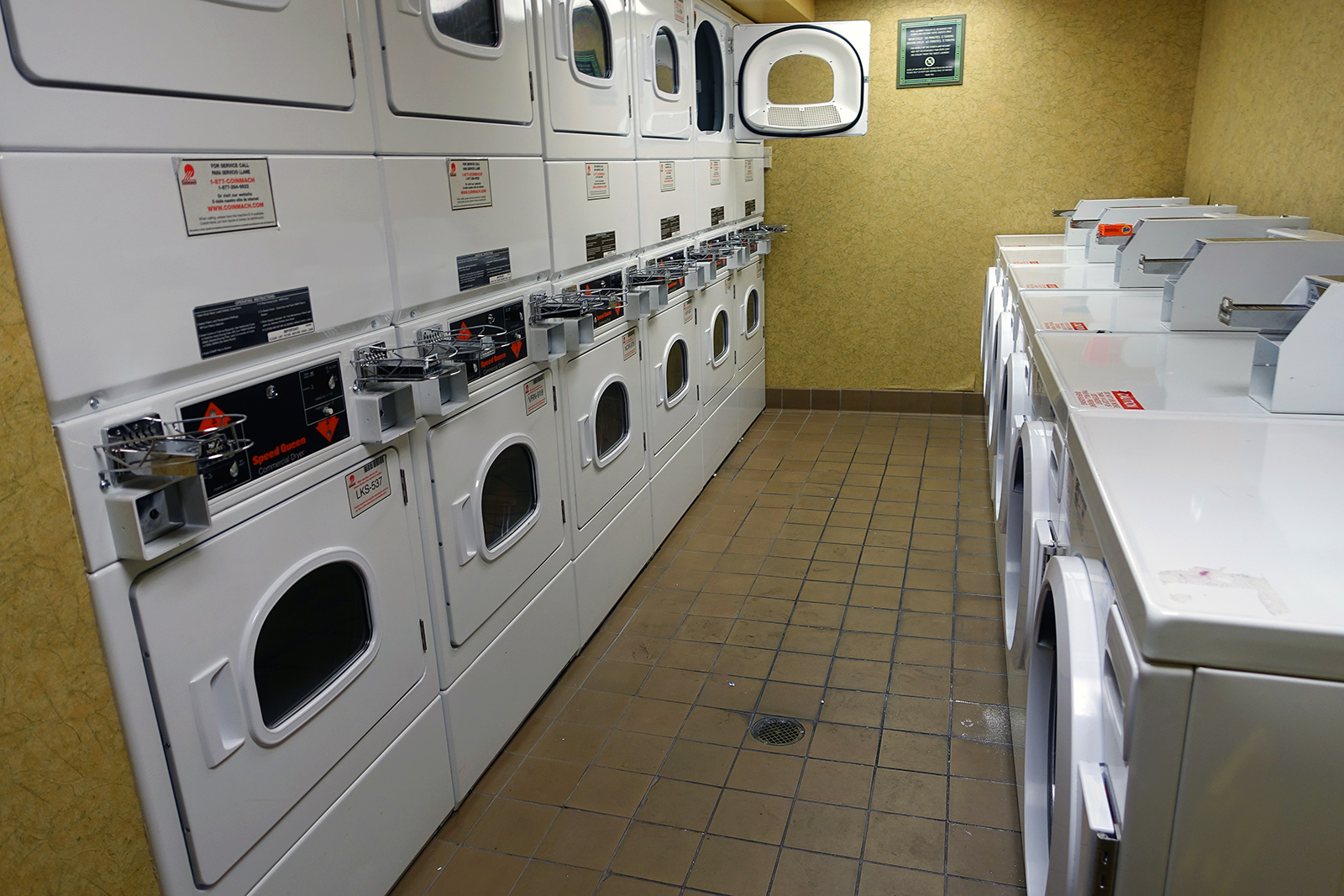 a row of washers and dryers in a public laussony