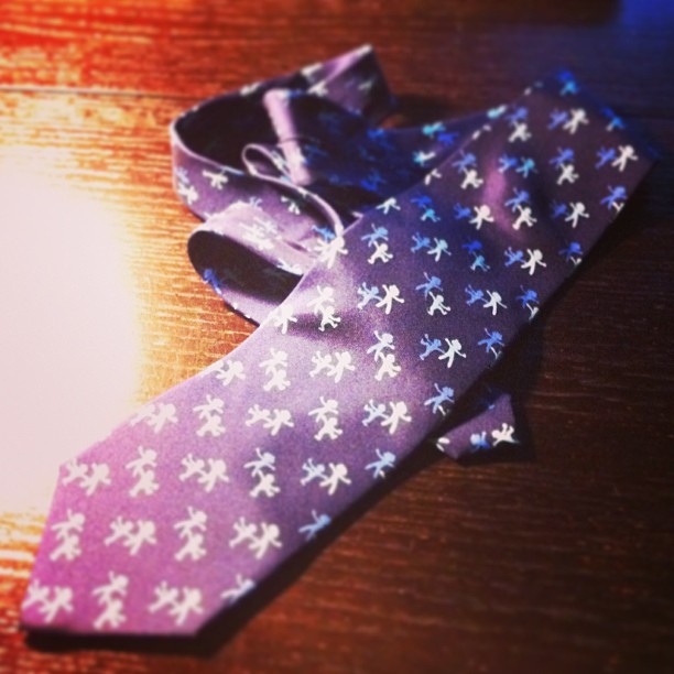 the purple and white tie is worn by someone on the table