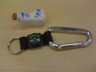 a bottle, a carabiner, and an id badge sitting on a table