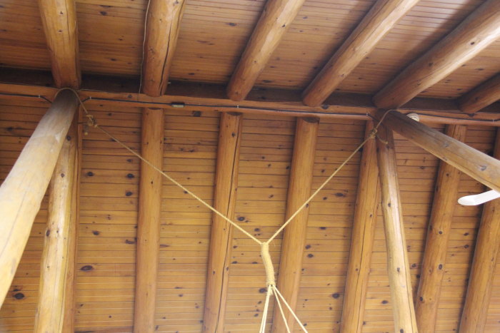 the ceiling of a large wooden cabin with some strings