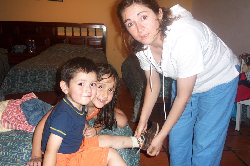 a woman poses with a boy and a little girl next to each other