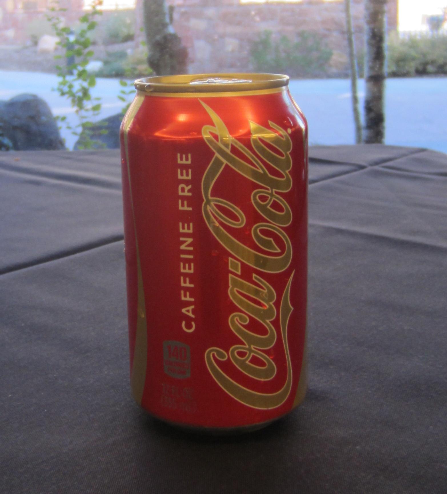 a red can of soda sitting on top of a black table