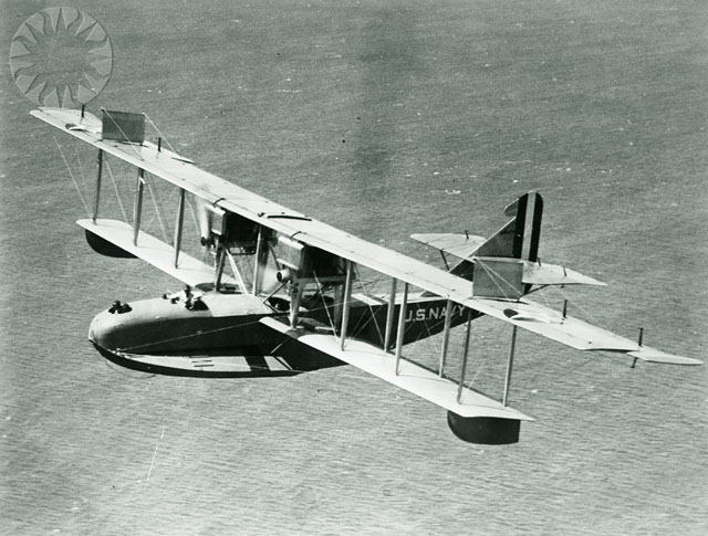 an old airplane flying over the water