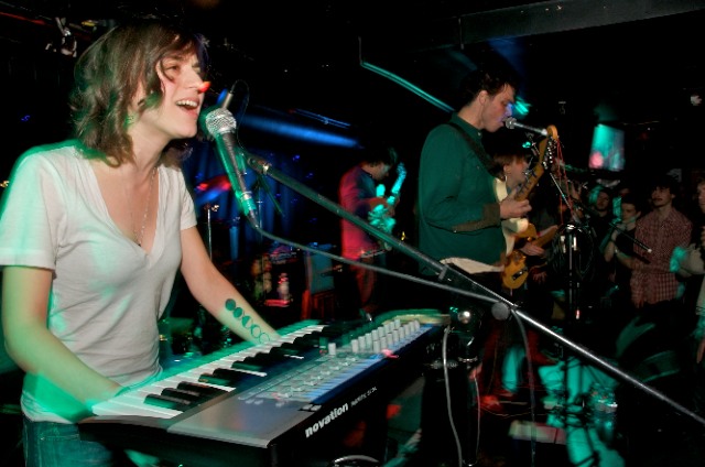 a person is playing piano in front of microphones