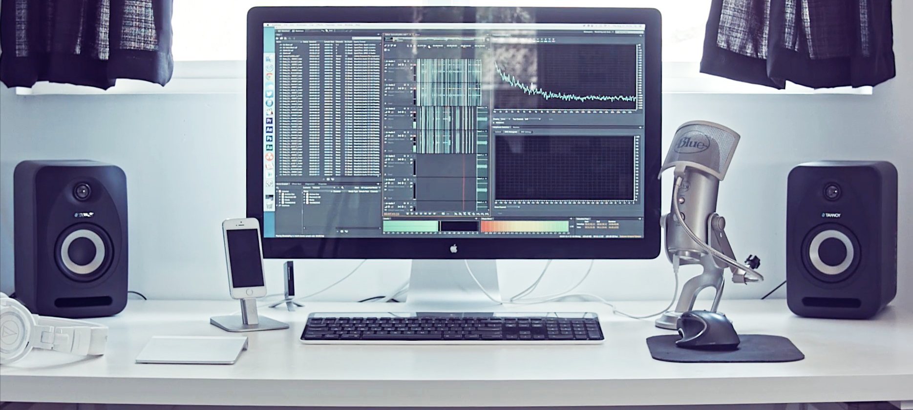 a monitor, keyboard and speakers are sitting on the desk