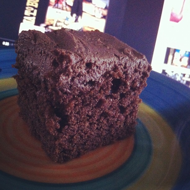 a chocolate cake with green stripes sitting on top of a plate