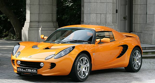 an orange sports car parked next to two columns