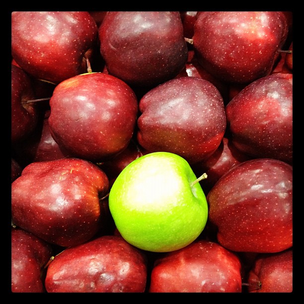 a close up of a green apple amongst other fruit