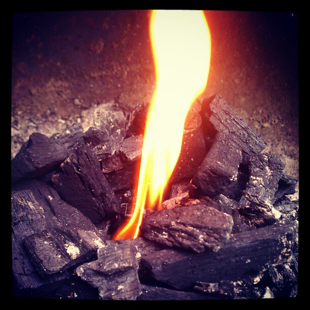 a bright flame burning over a large pile of coal