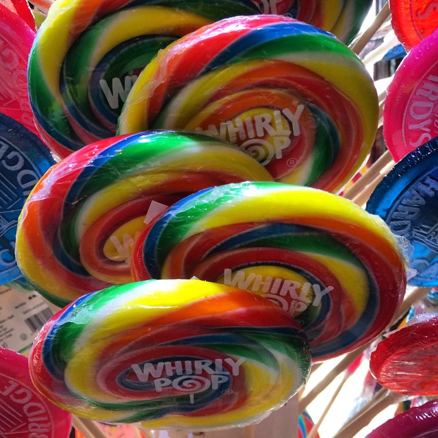 a variety of brightly colored lollipops in a holder