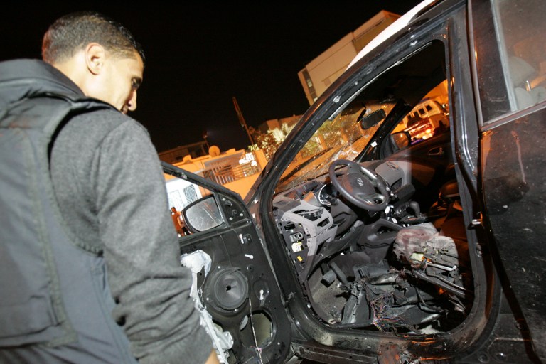 a man standing next to an overturned car