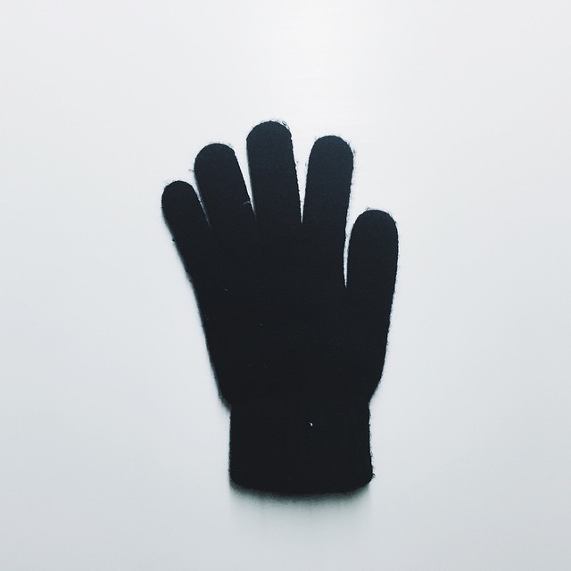a black mitten on a white surface