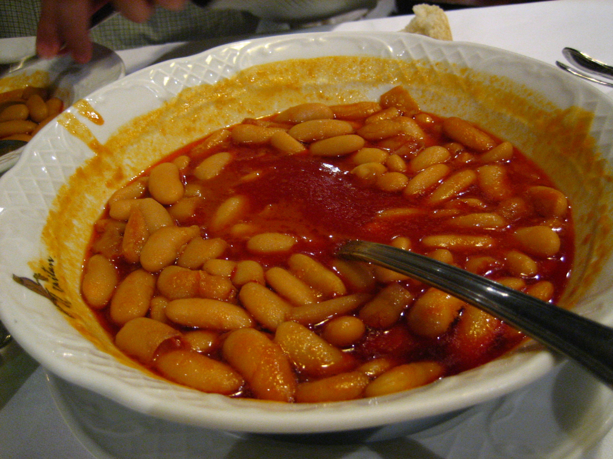 a bowl full of some beans on a white table