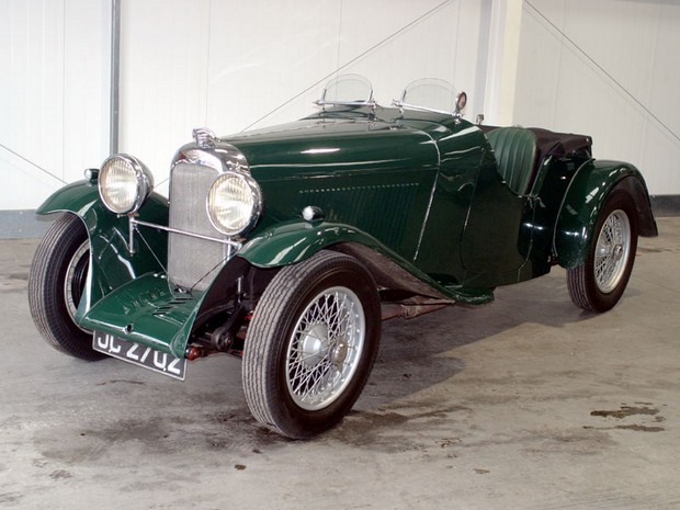 a green vintage sports car parked in a garage