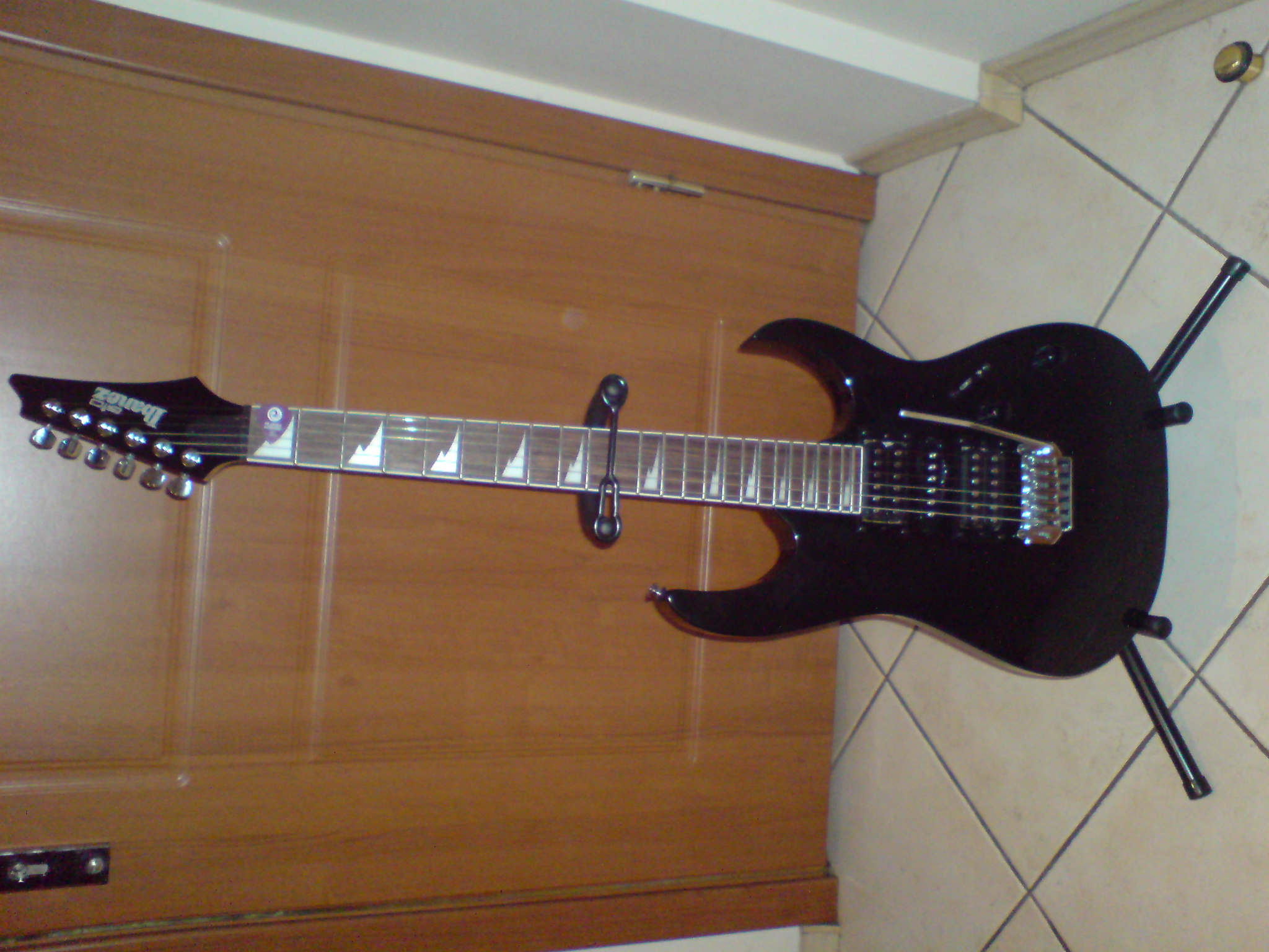 a black guitar is sitting on a floor