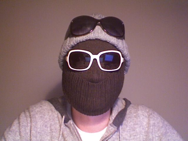 a young man wearing a knit mask and sunglasses