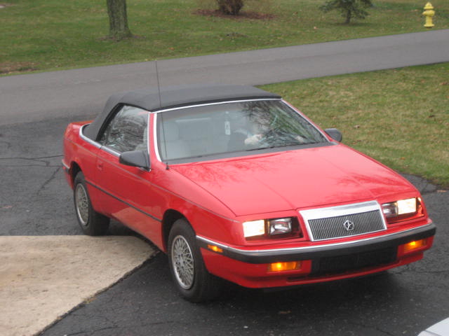 a red car sits parked next to a curb