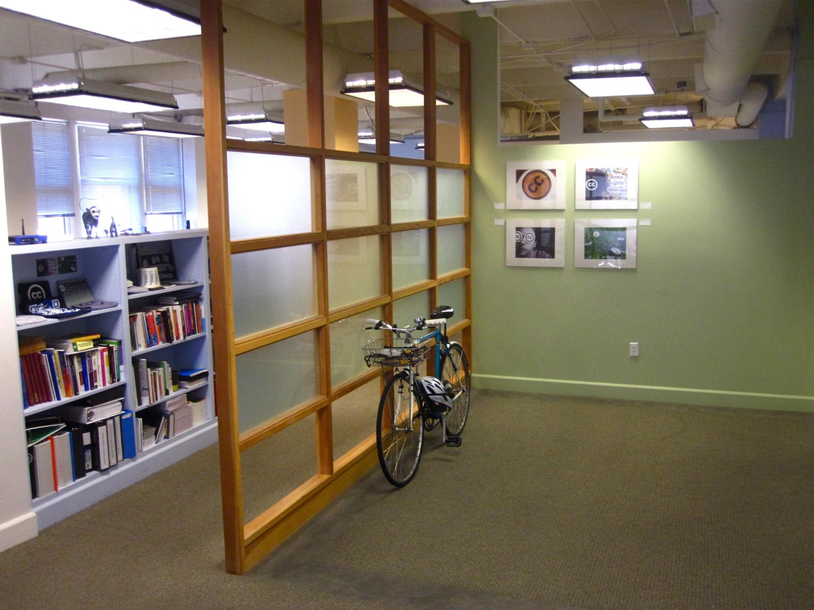 a bicycle leaned against the wall inside a book case