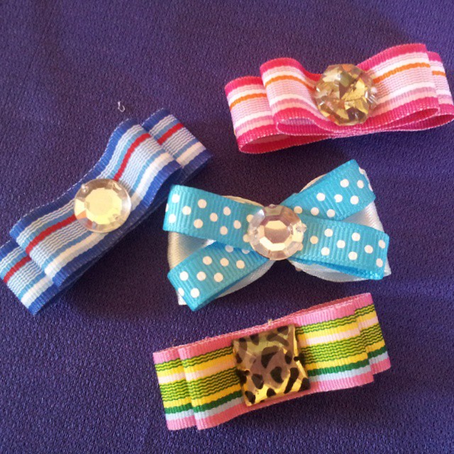 five colorful hair clips laid out on a blue surface