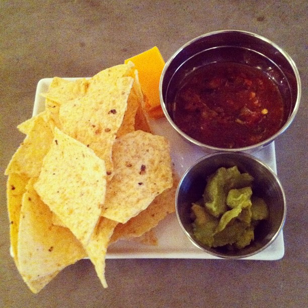 some chips and salsa sit on a plate