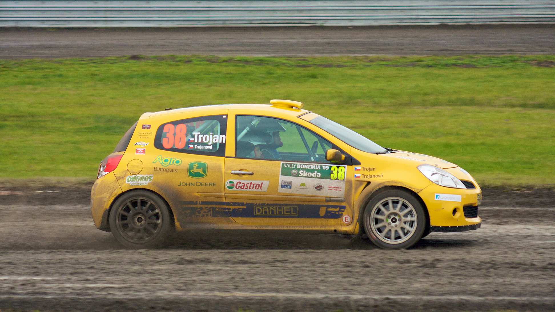 a small yellow race car driving through a dirt track