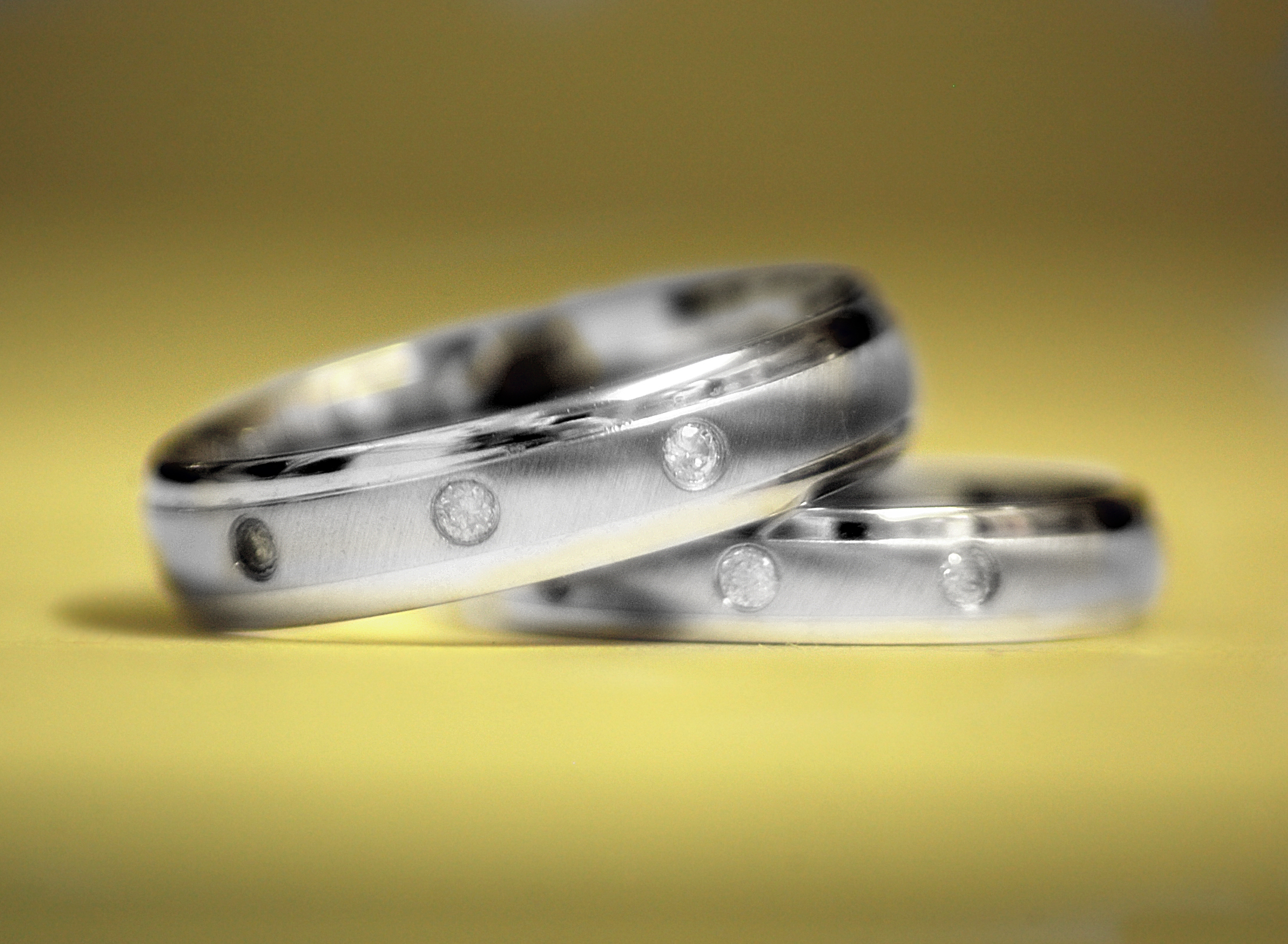 two wedding bands with four diamonds on them