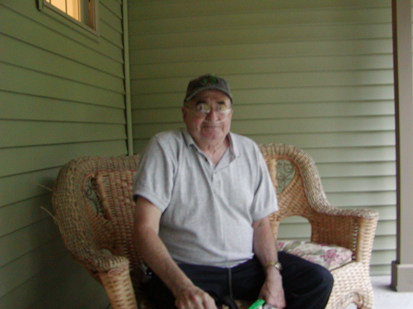 an elderly man sitting in a chair with his hand in the other pocket