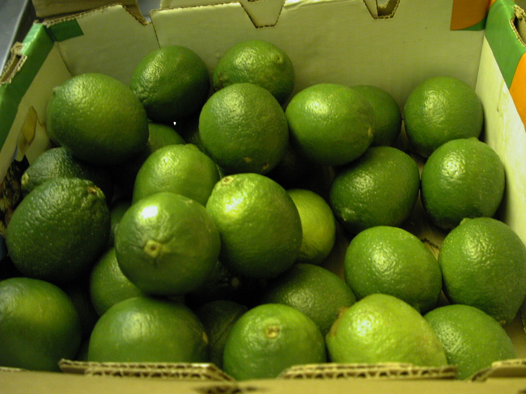 a bunch of limes in a cardboard box