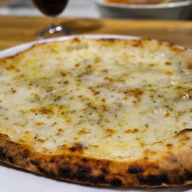 a cheese pizza sitting on top of a white plate