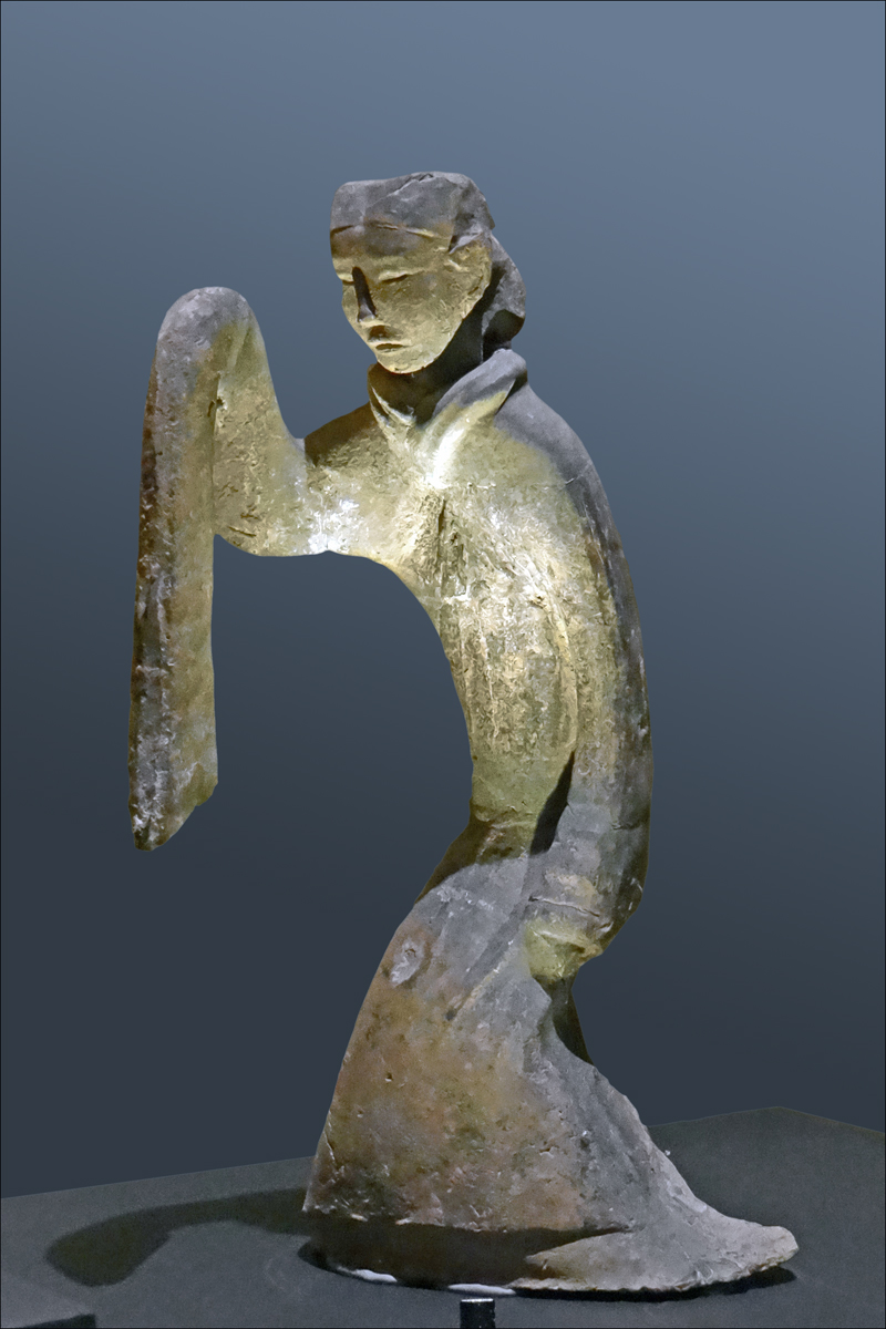 an ancient bronze statue of a person holding soing in it's hand