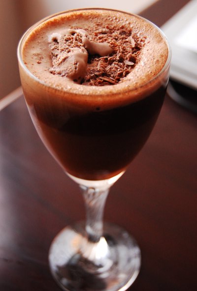 a drink with chocolate topping on a brown table