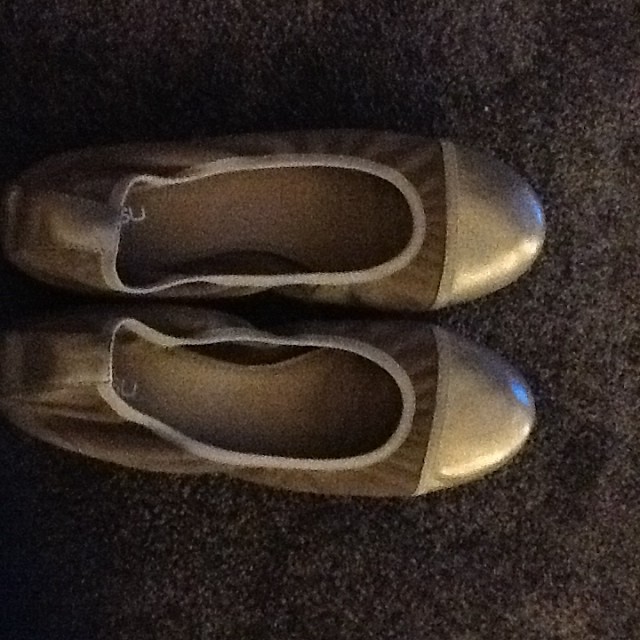 a pair of silver colored shoes with white outs
