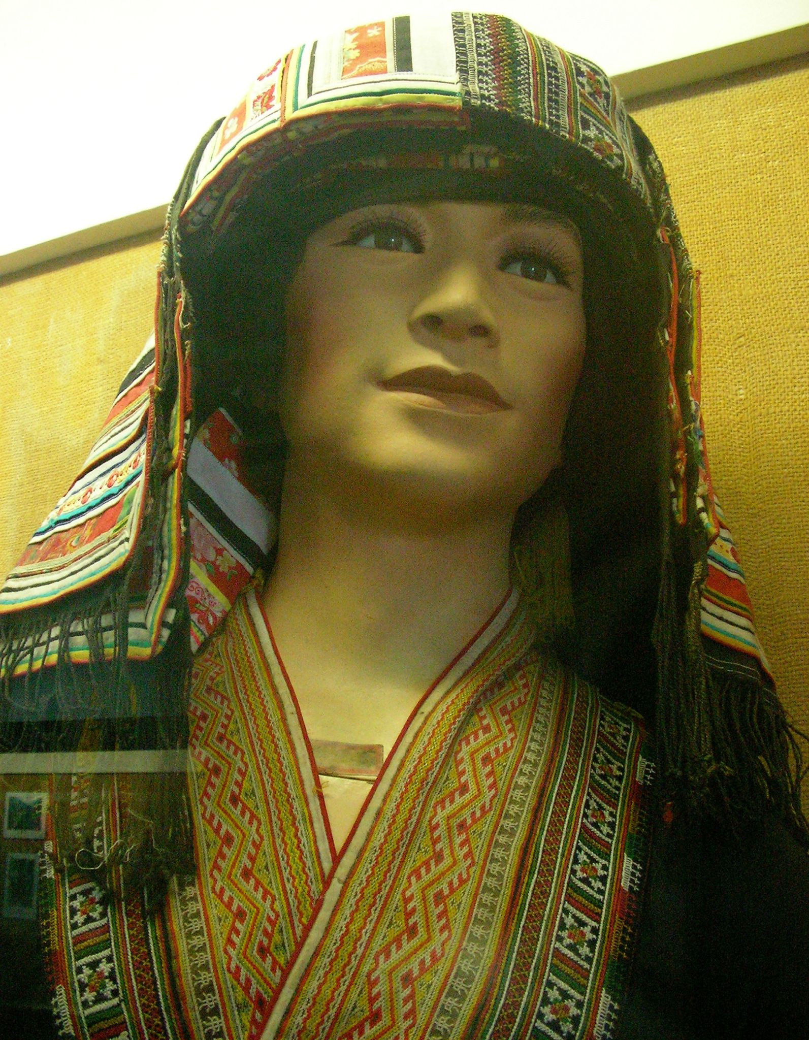 a person wearing a hat and scarf on display