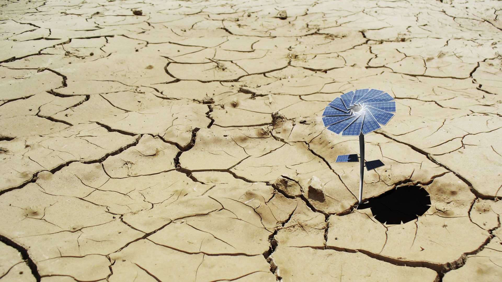 a wind driven umbrella sitting on the floor of a dried up river bed