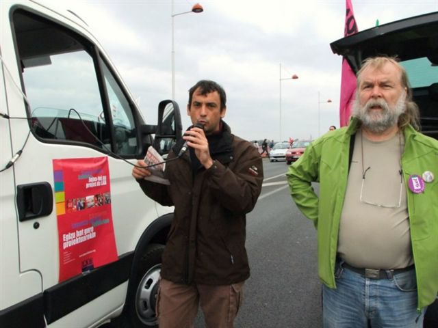 two men standing on the side of a highway