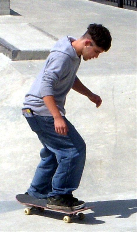 a young man riding his skateboard down a ramp