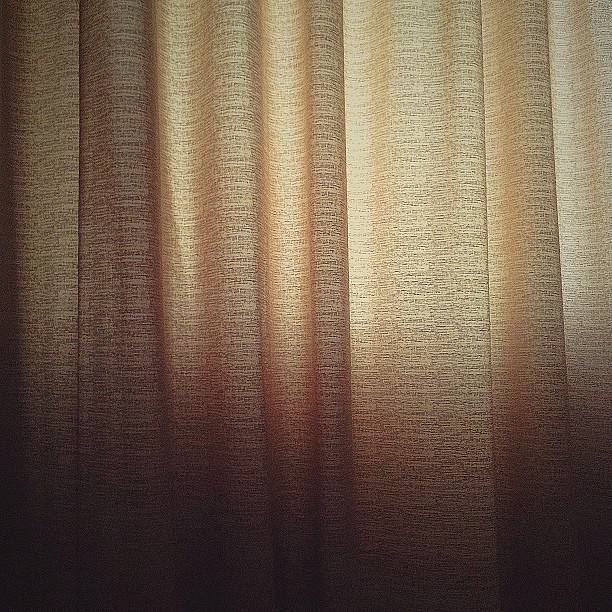 a view of an open window with a curtain drawn