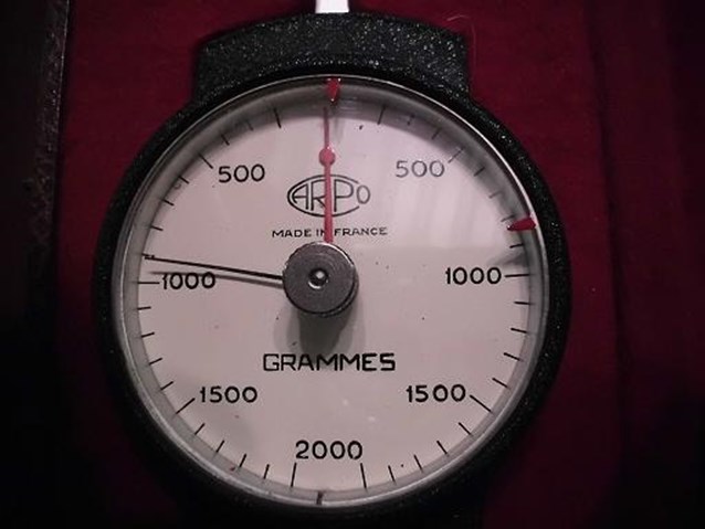 a gauge for gramimes is being displayed on red cloth