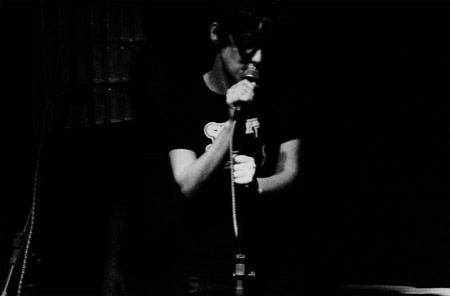 a black and white image of a man singing into a microphone
