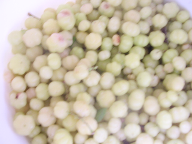 some green berries with pink and white centers are in a bowl