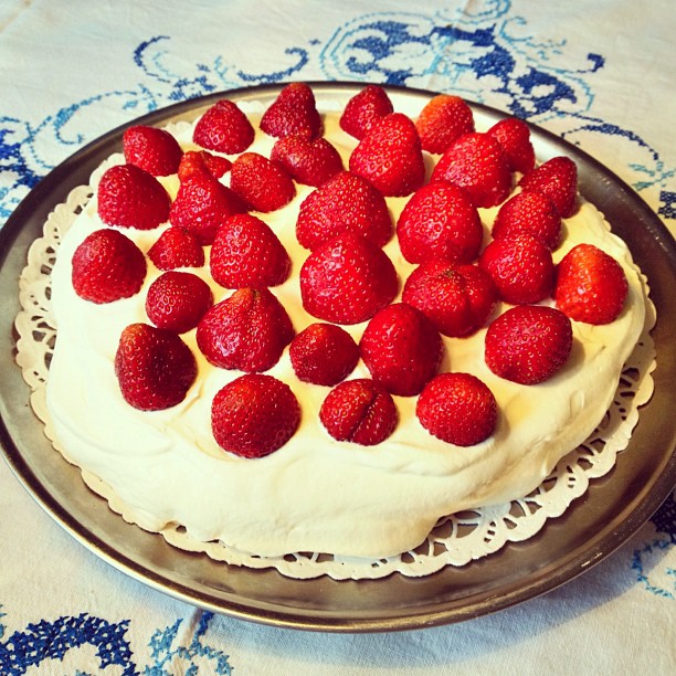 the cake has strawberries on it sitting in front of the plate