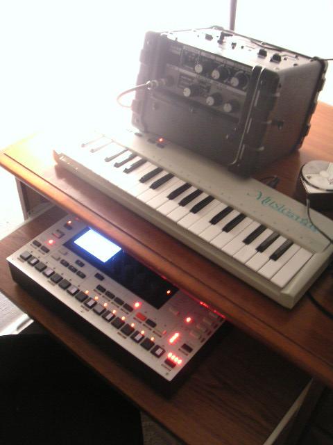 electronic music instruments displayed on a table near a amp