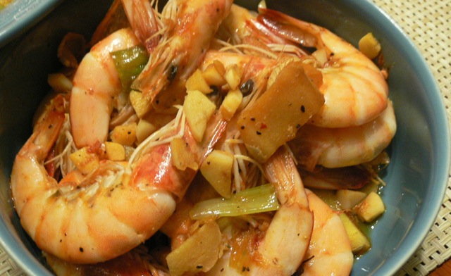 a bowl of shrimp with potatoes and peppers