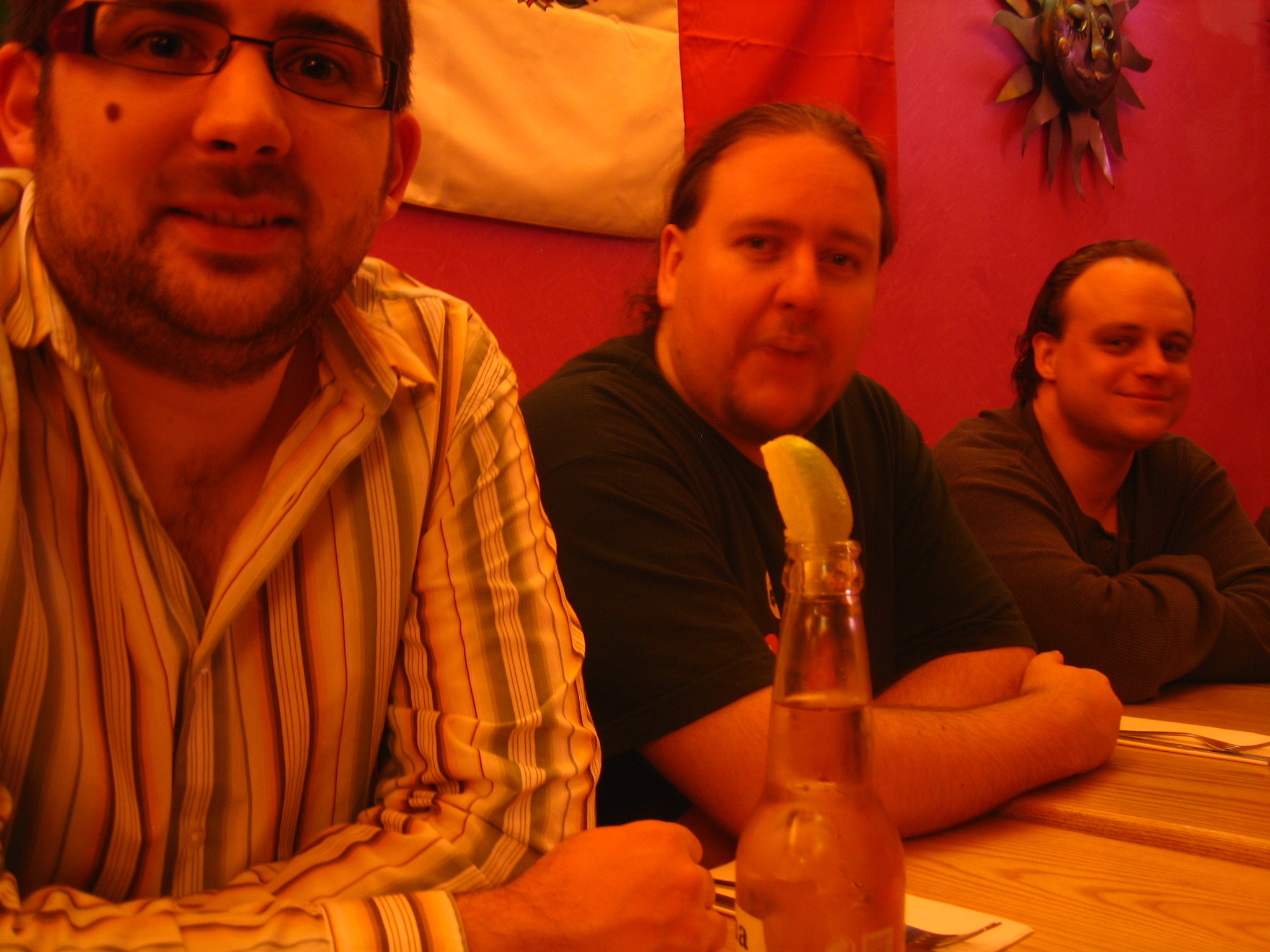 three men in a restaurant with a beverage in each glass