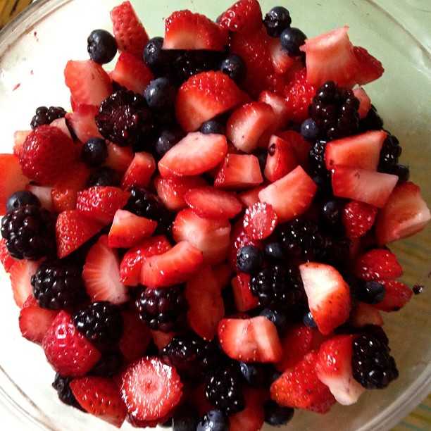 berries, raspberries and blueberries are in a bowl
