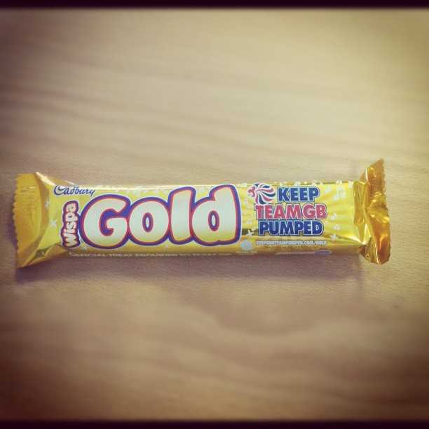 a gold colored candy bar on a wooden surface